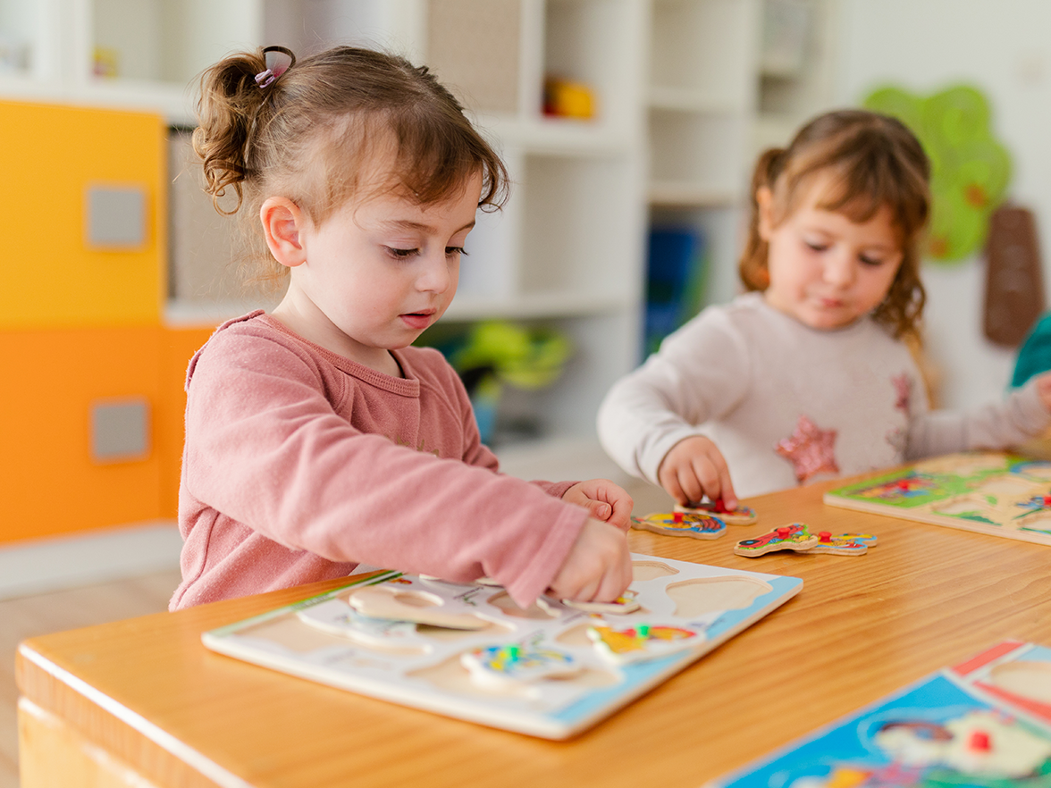 Two children using a playmat at a center