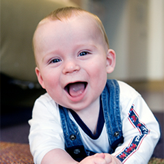 Infant boy crawling and smiling