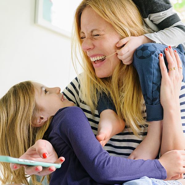 A woman playing with two children