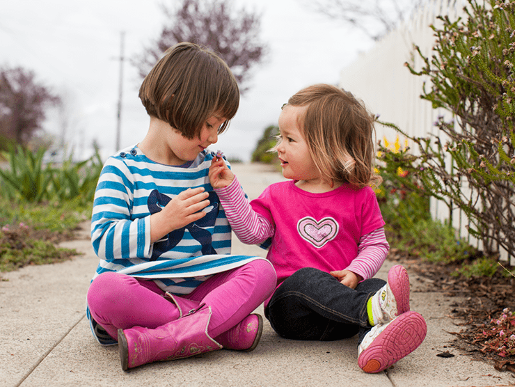 Two young girls playing outside