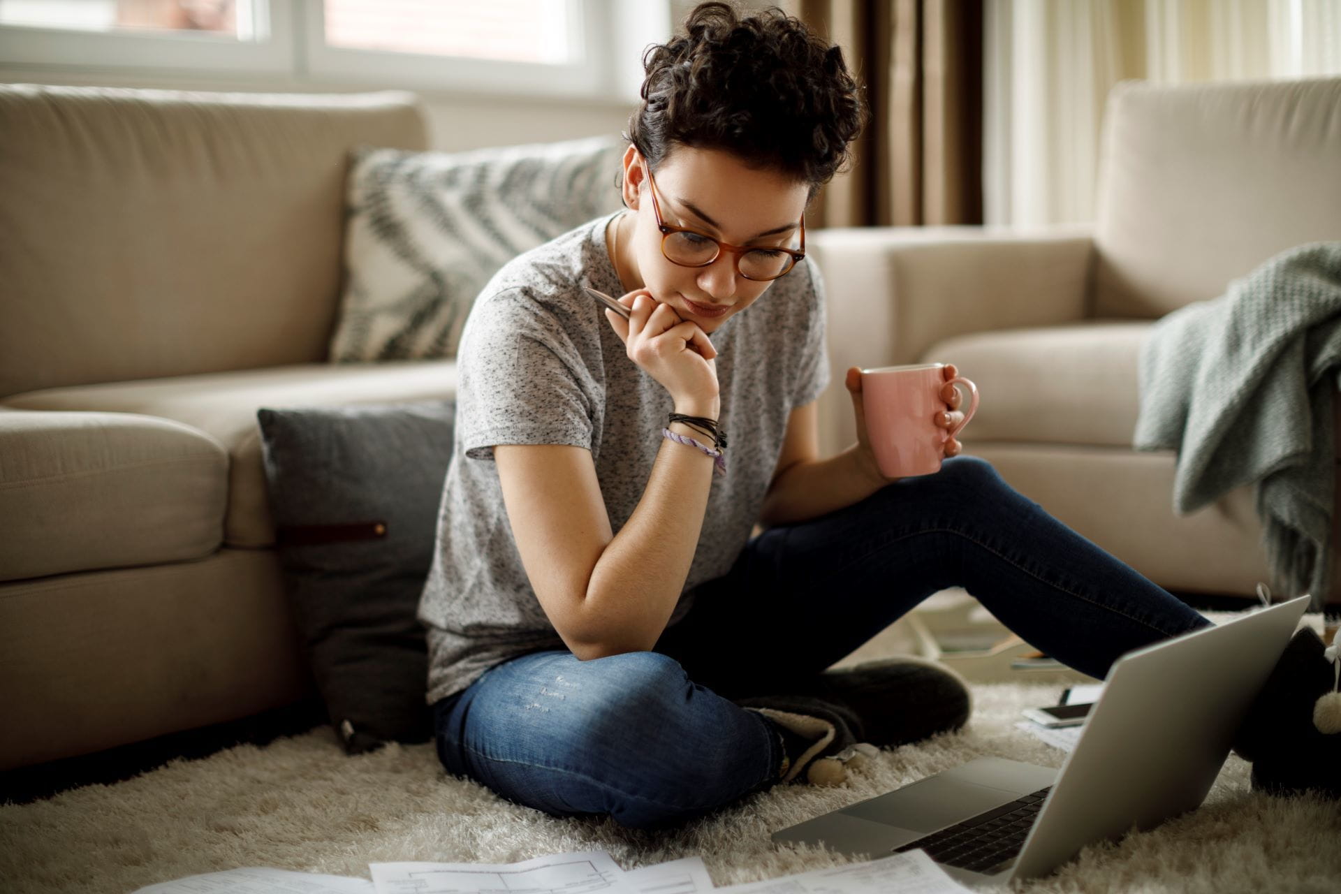 person looking at computer with mug