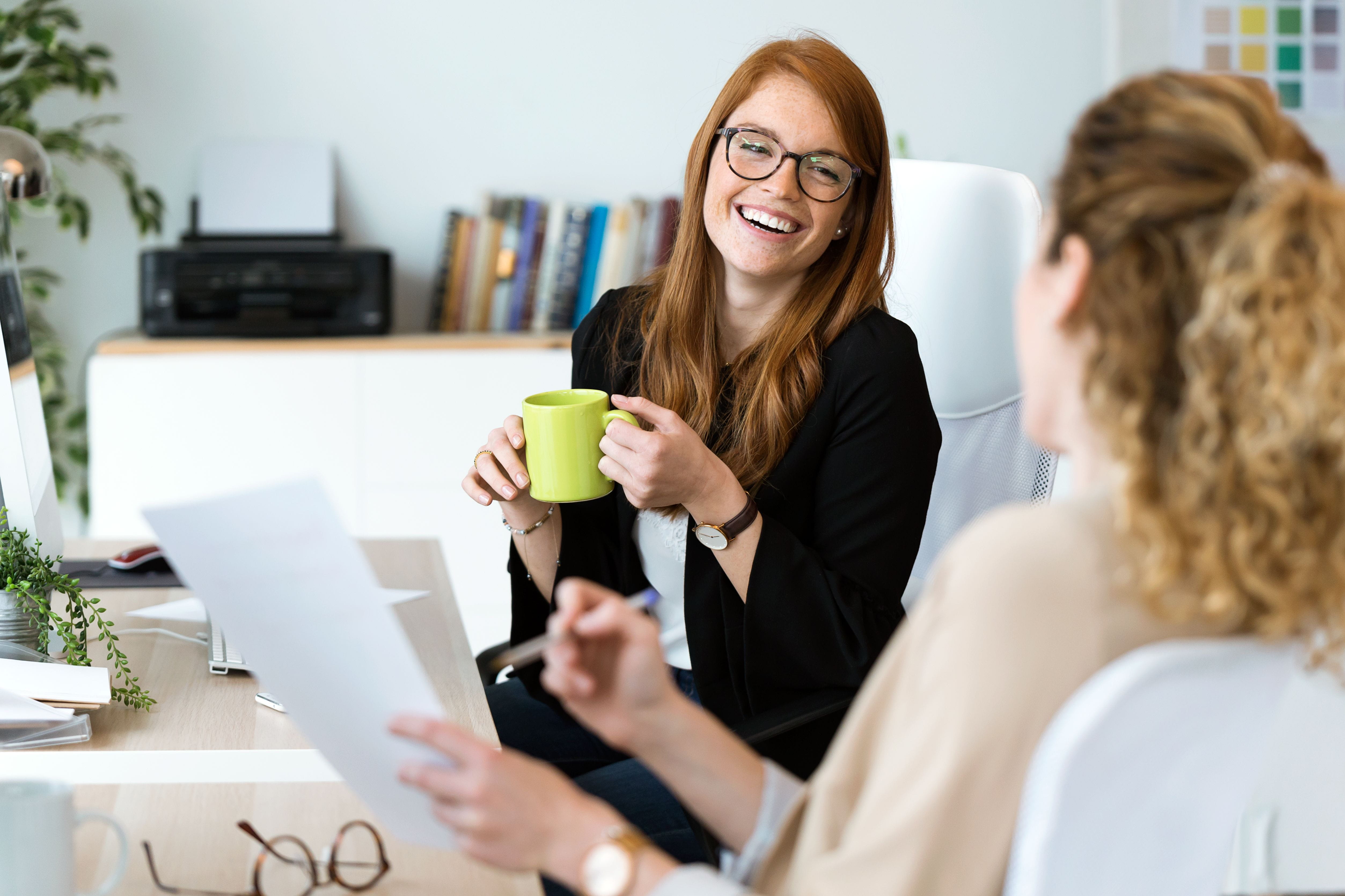 woman laughing holding a mug