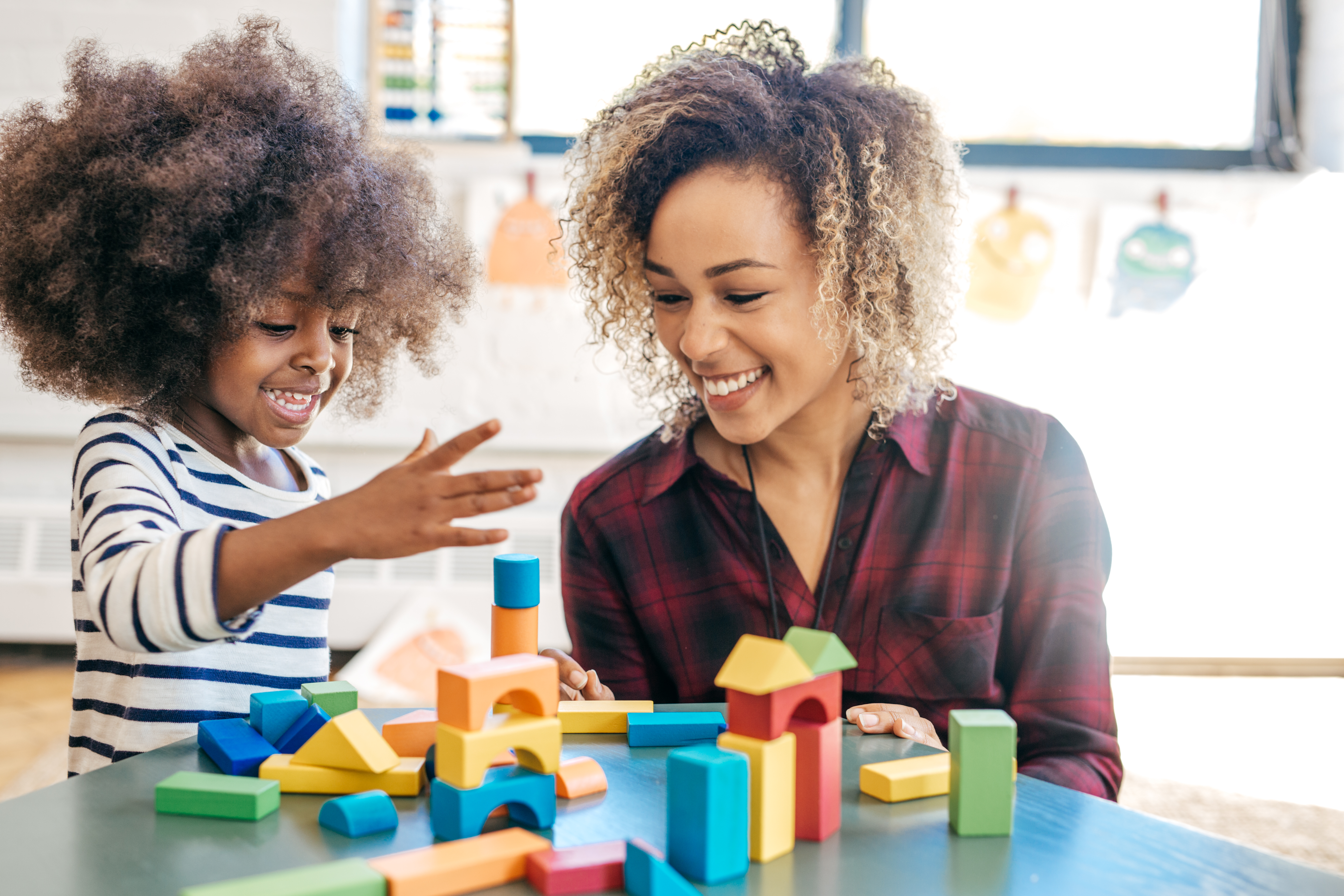 woman using building blocks with child