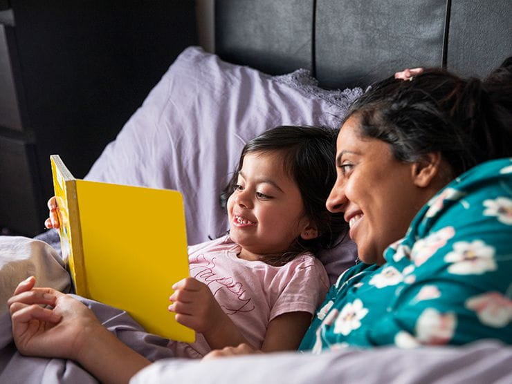 Mother and daughter reading before bed