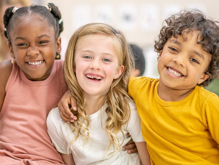 Three school-aged children posing for a picture