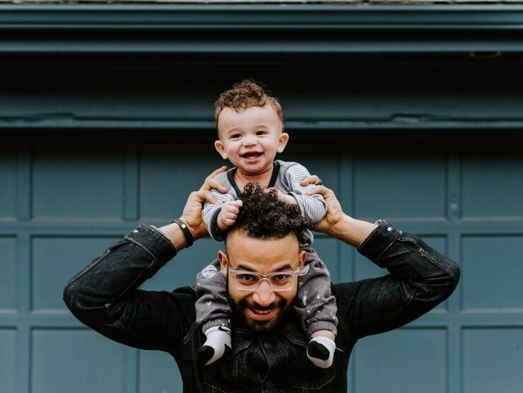 A father carrying his toddler son on his shoulders