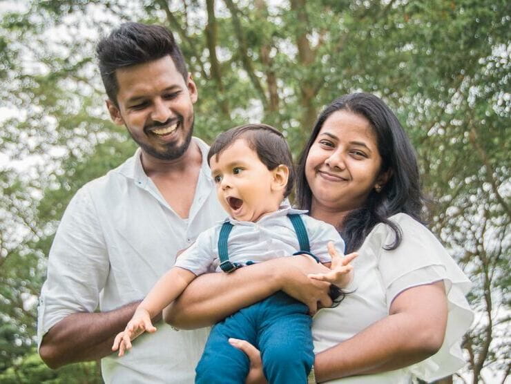 Family of three holding a young child