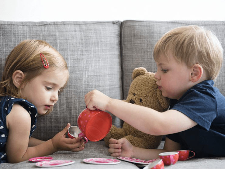 Young boy and girl playing on the couch