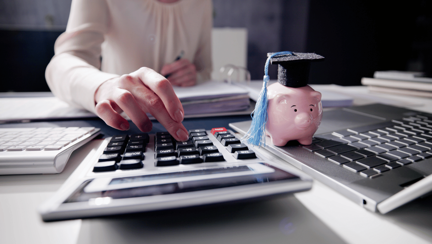 calculator and piggy bank with graduation cap